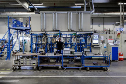 Technician commissioning production equipment on the factory floor